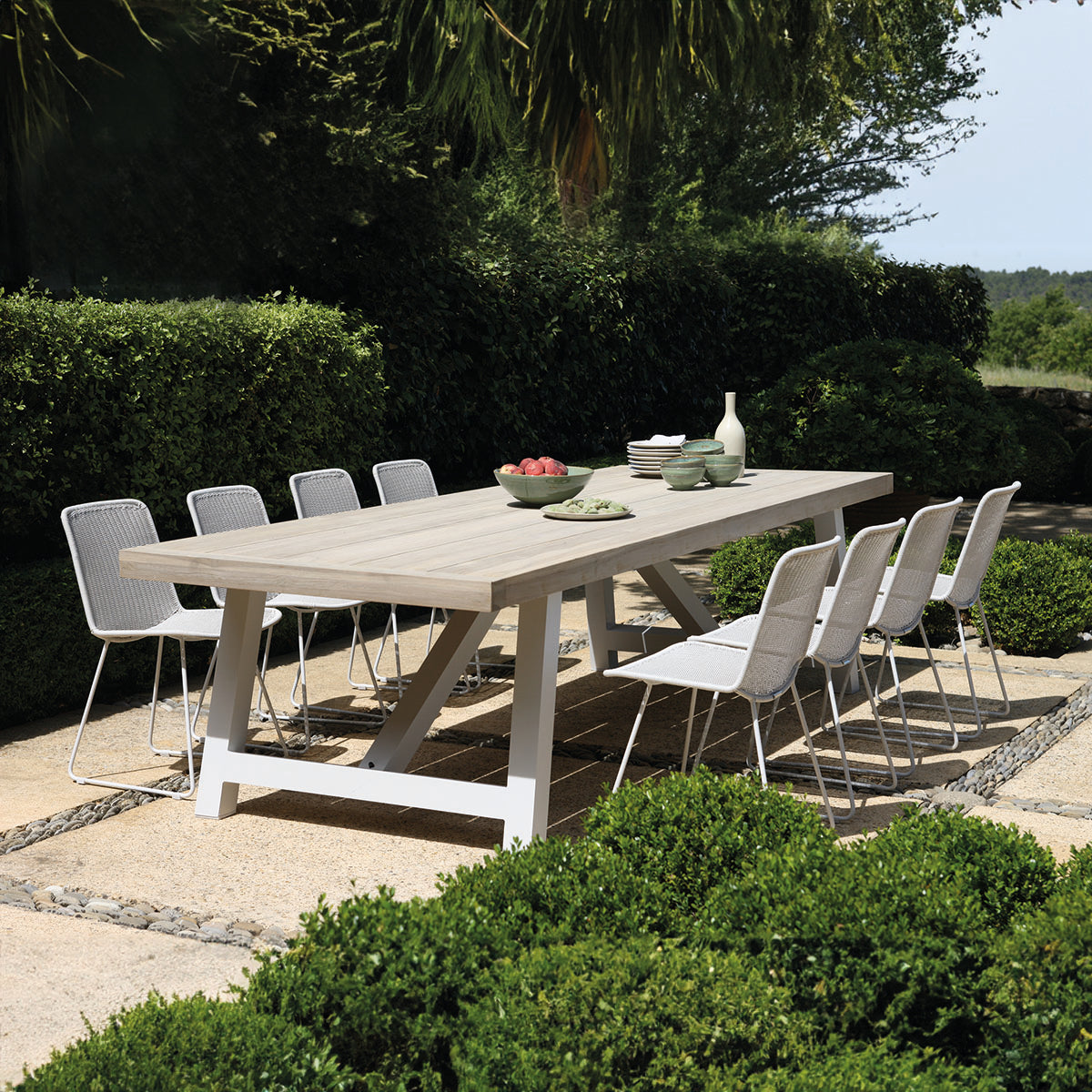 Olive dining side chairs with Hobson aluminium and teak top dining table set outdoors.