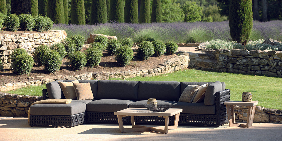 Logan outdoor wicker modular furniture collection situated in garden setting.