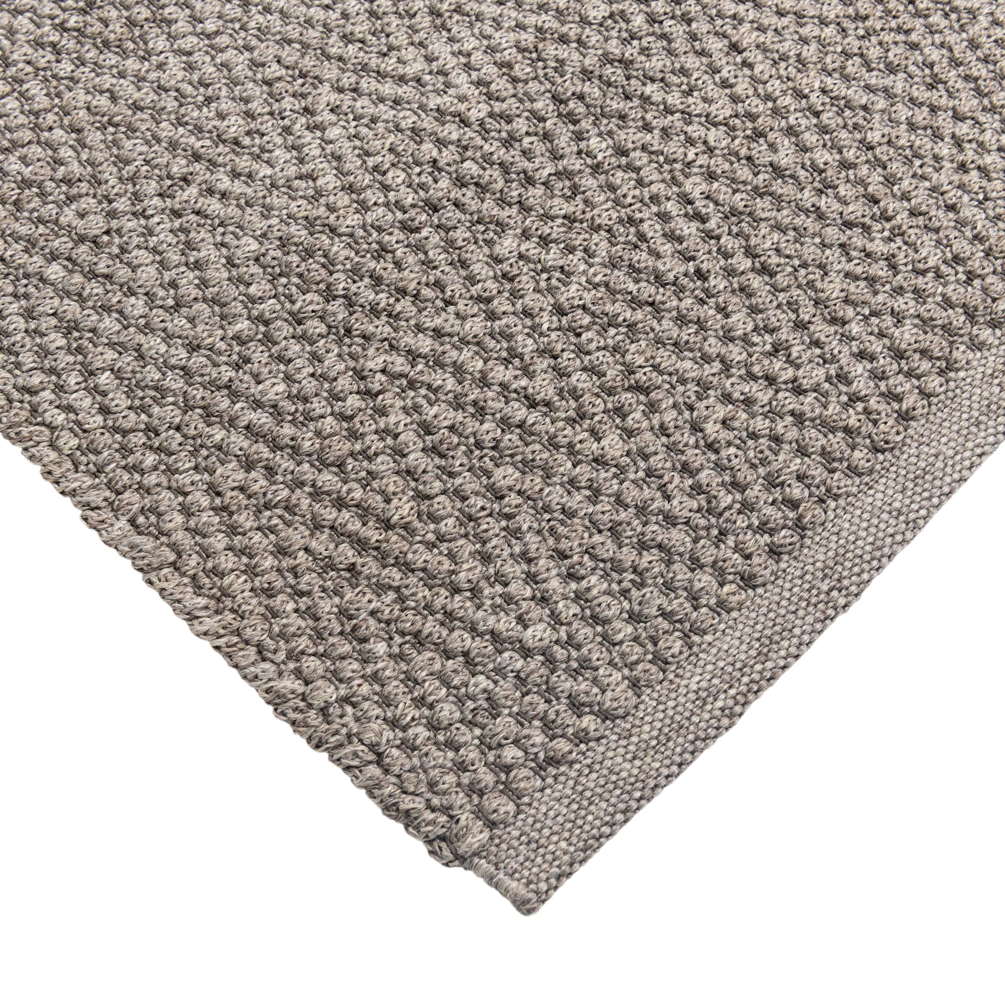 Close-up of a textured gray rug on a white background