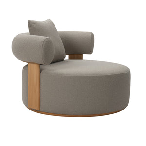 Front angle view of Cap Ferrat teak lounge chair with round seating and armrest with plush seating fabric and on back arm rest with pillow cushion. 