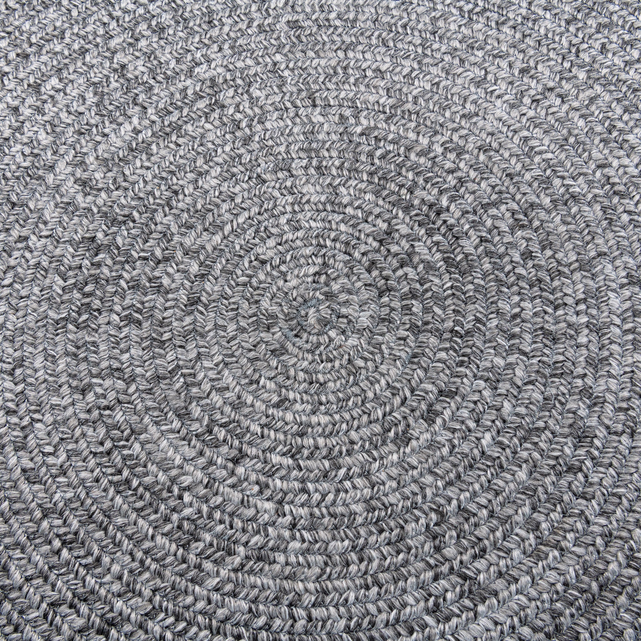 Closeup view of Cirra outdoor round handwoven floor rug in dark grey. 