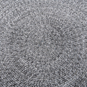 Closeup view of Cirra outdoor round handwoven floor rug in dark grey. 