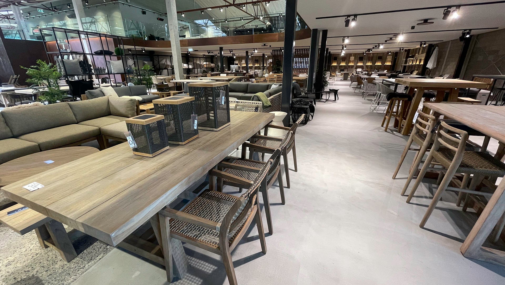 Modern outdoor furniture store with various tables, chairs, and decor items.