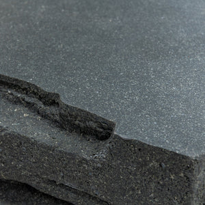 Closeup view of Fred outdoor coffee table with its jagged edges. Black finish with a trapezoid look. 