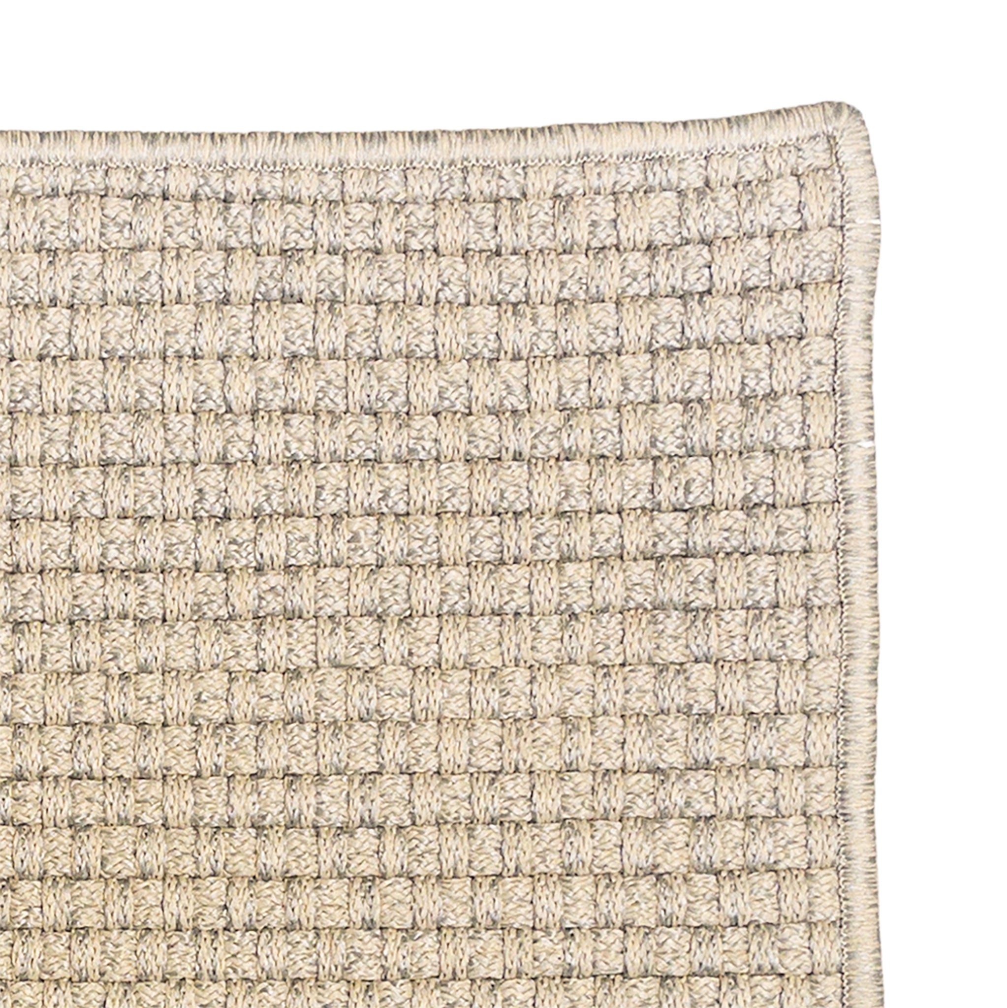 Close-up of a textured beige rug with a grid pattern on a white background