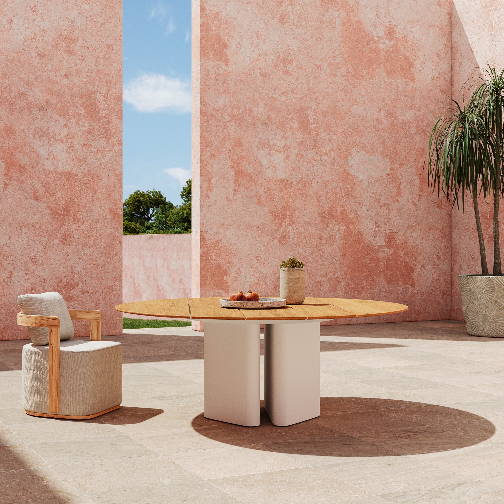 Round teak Monte Carlo dining table on exterior patio. 