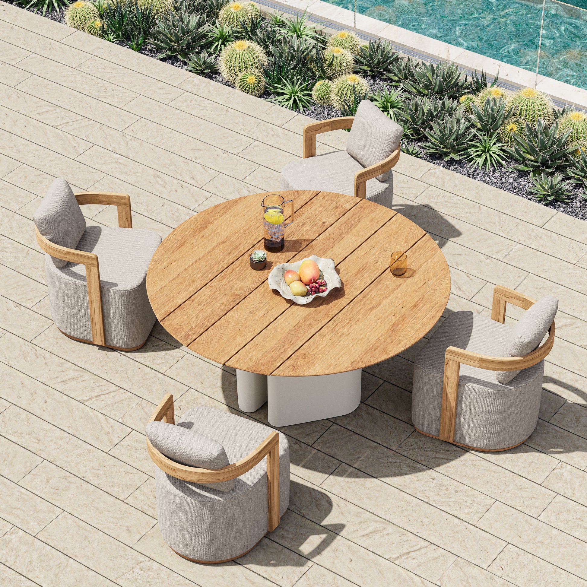 Overhead shot of Monte Carlo round teak dining table poolside surrounded by dining chairs.