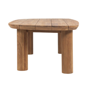 A rustic wooden table with a rounded, multi-panel tabletop and four thick cylindrical legs, shown on a solid white background.