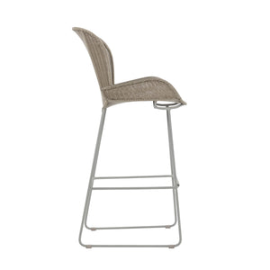 Nairobi Outdoor Bar Stool in Greige / Linen with woven resin wicker seat, curved backrest, integrated armrests and powder-coated aluminium frame. Side view.