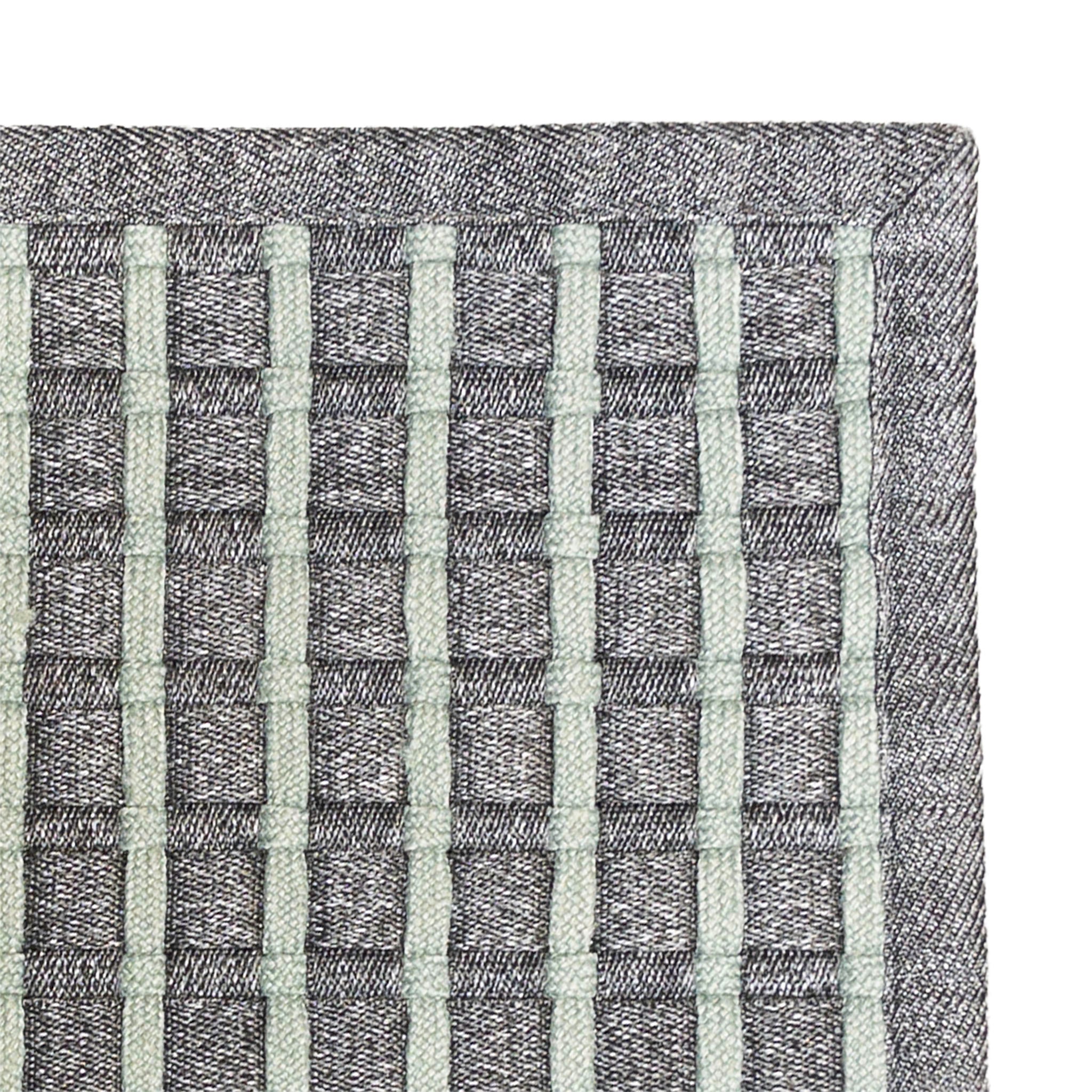 Close-up of a dark grey and chinos green textured fabric with a grid pattern on a white background