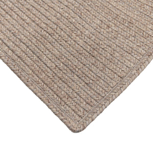 Close-up of a textured beige rug corner on a white background