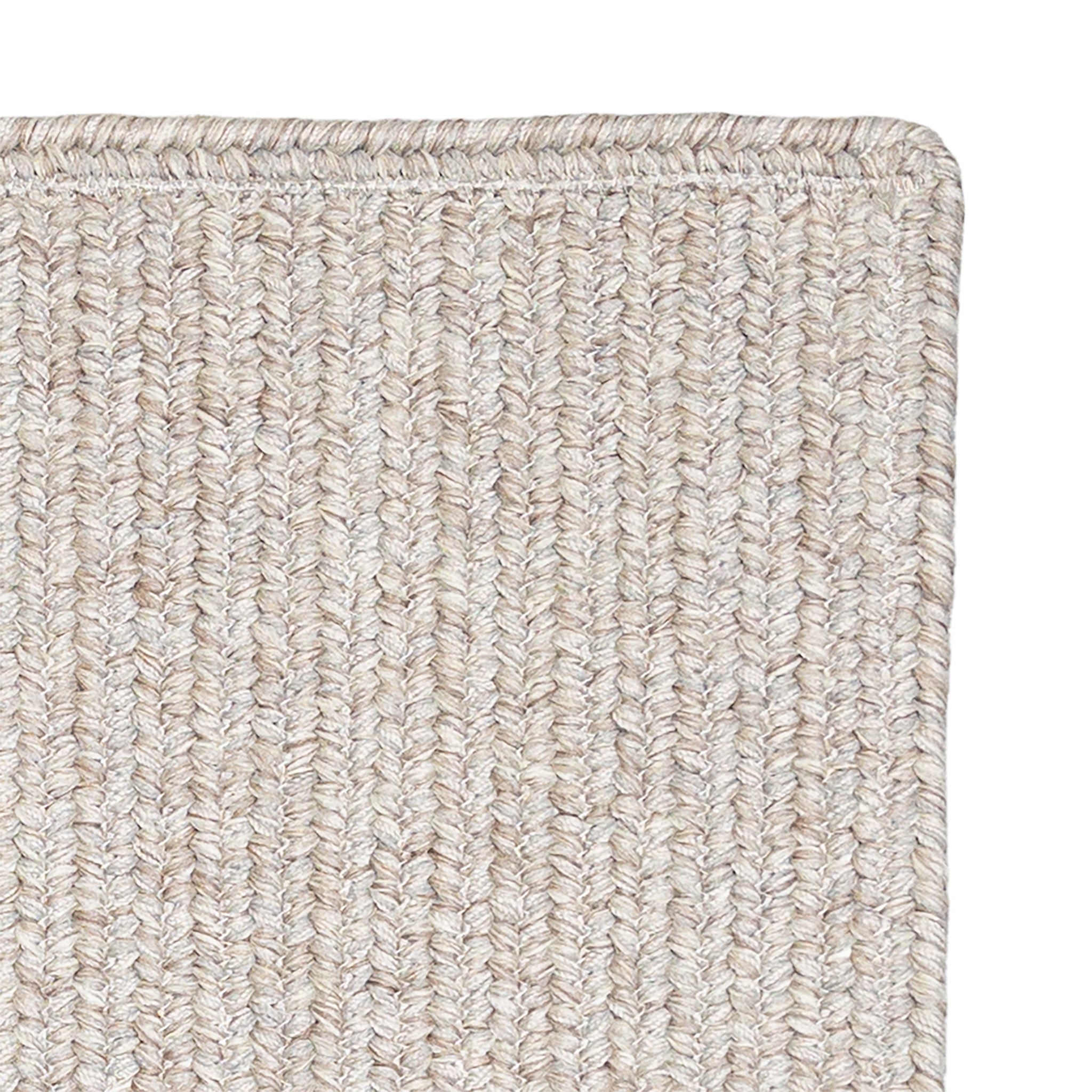 Close-up of a textured beige carpet corner on a white background