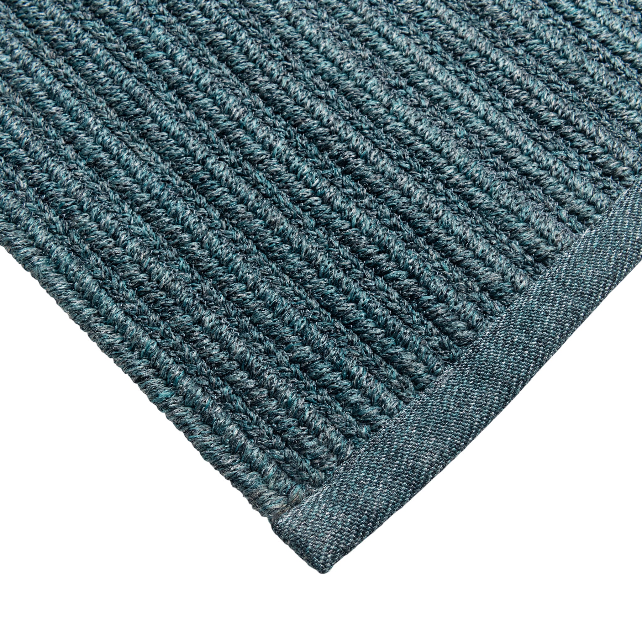 Close-up of a textured blue rug corner on a white background