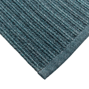 Close-up of a textured blue rug corner on a white background