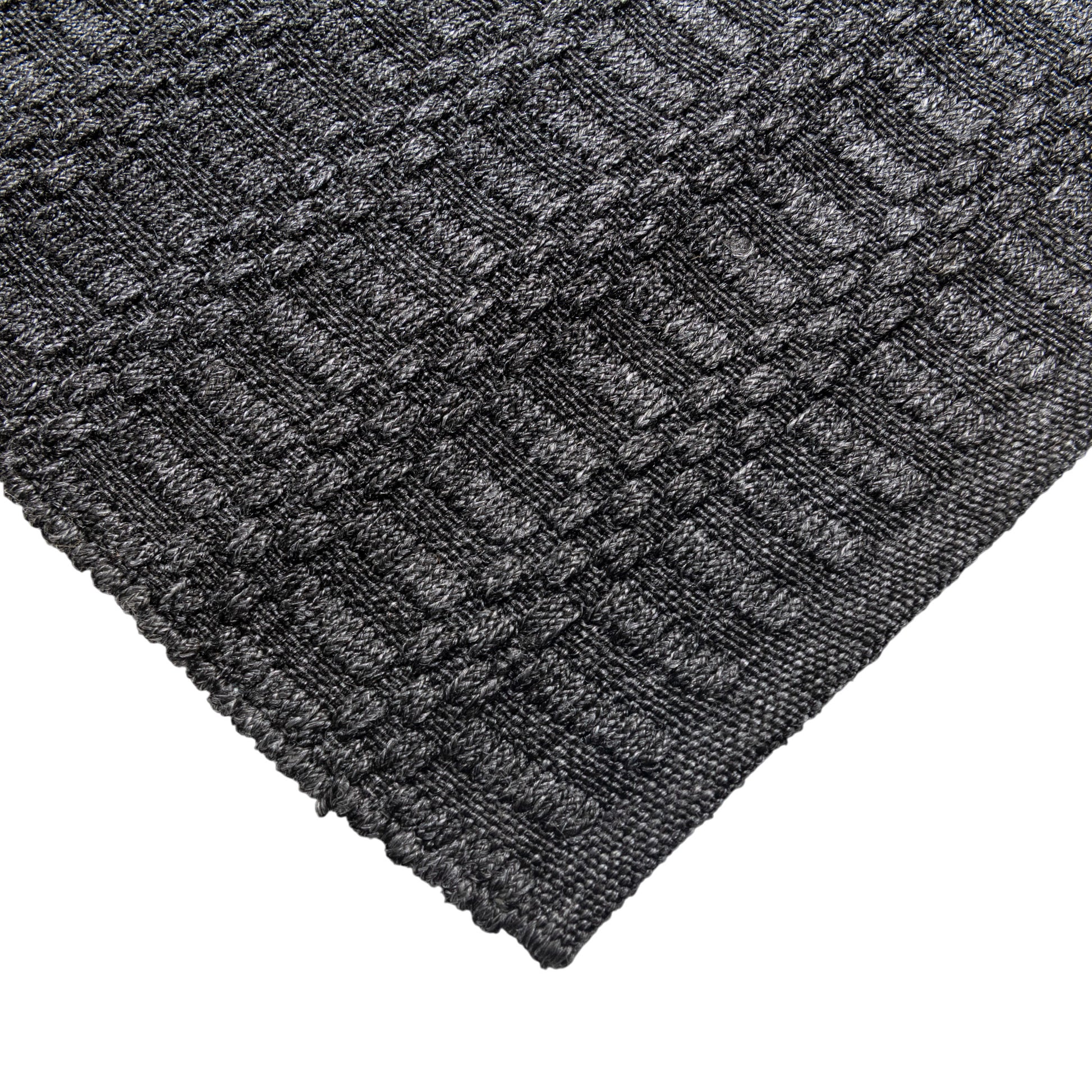 Close-up of a textured dark gray rug with a geometric pattern on a white background